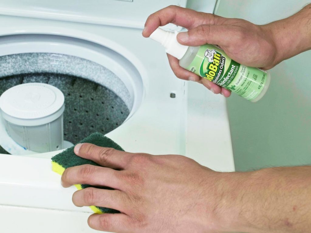 Cleaning the exterior rubber gaskets of washing machine with OdoBan to prevent mold and mildew.